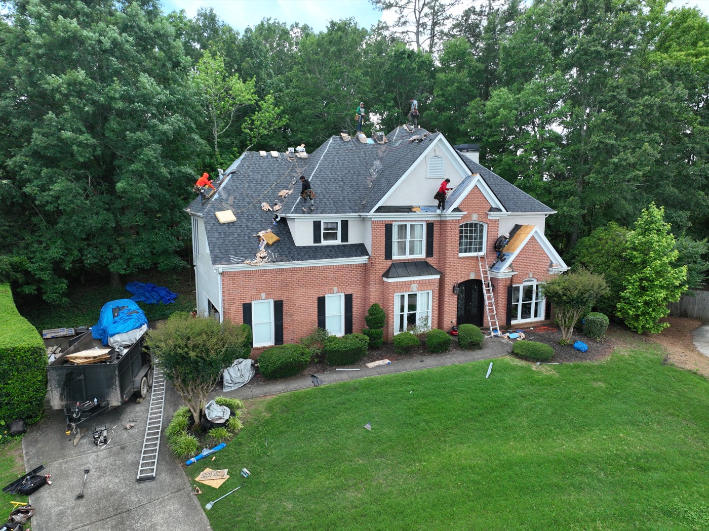 Roofing crew working on a brick home roof