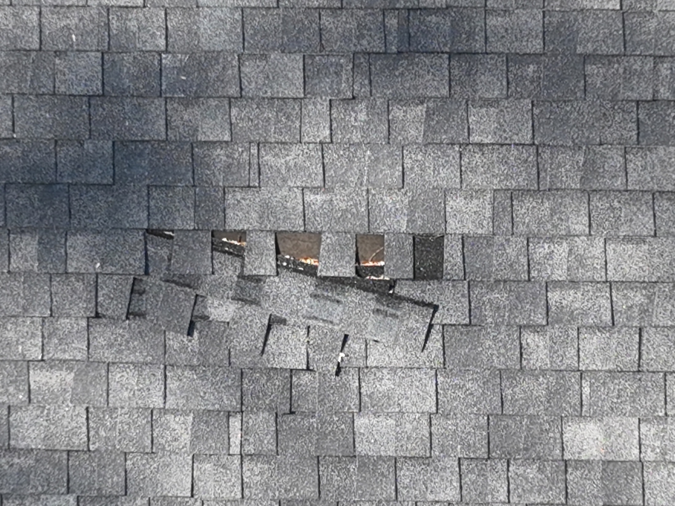 Drone photo showing storm-damaged shingles documented during a roof inspection