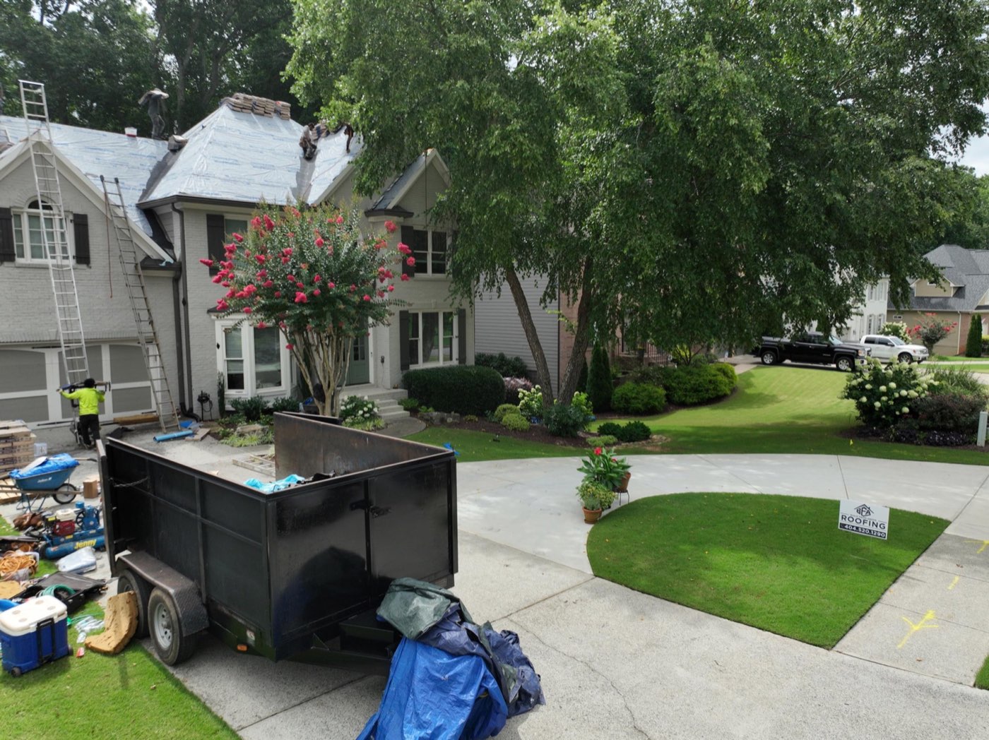 Suwanee GA roof replacement jobsite with crew and roofing materials
